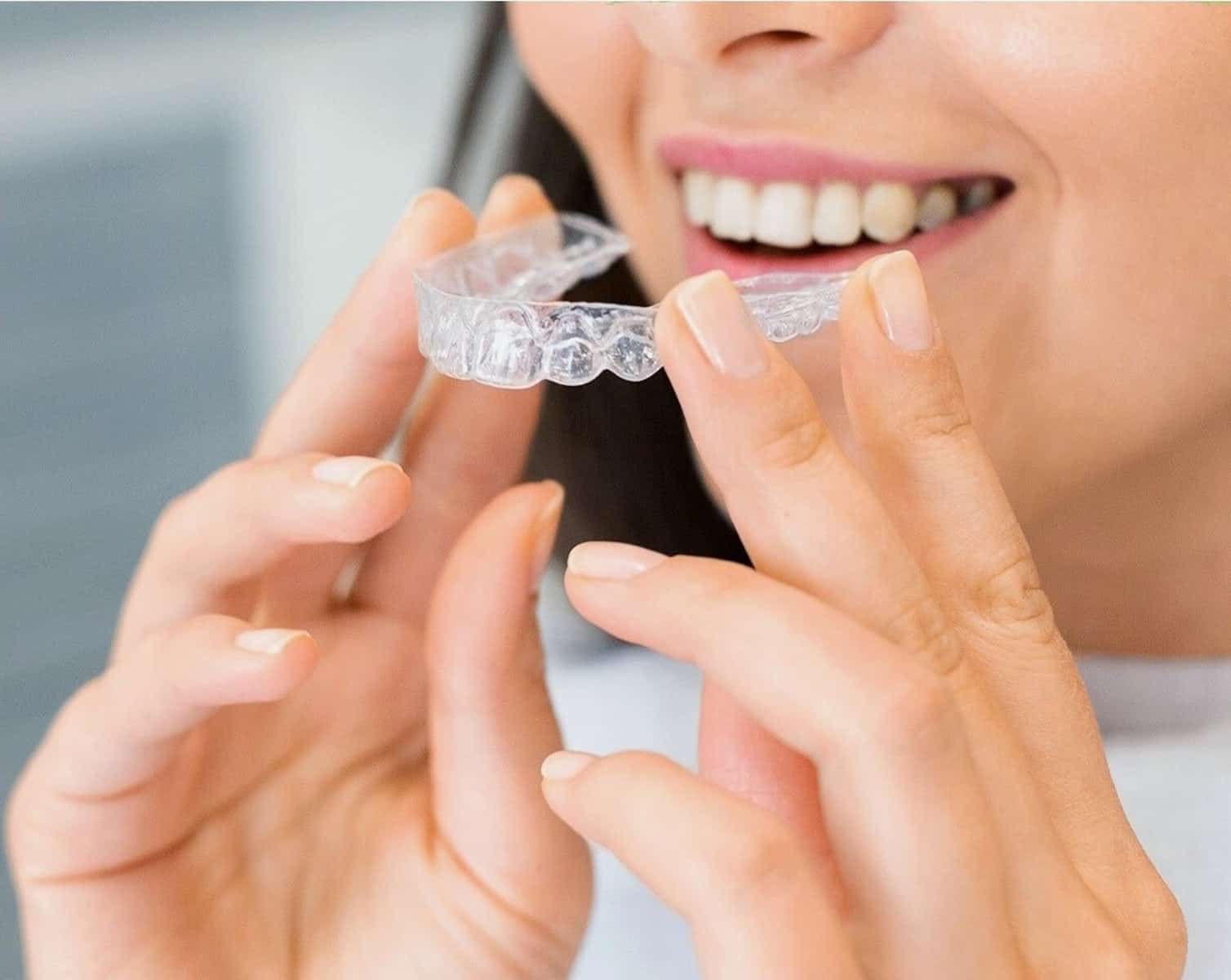 een vrouw houdt haar invisalign beugel vast