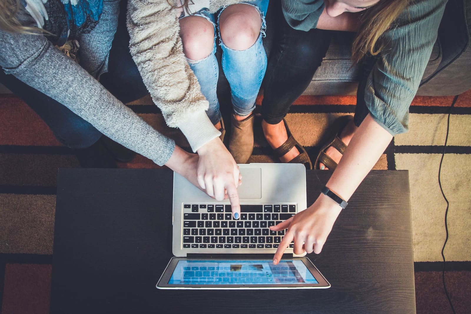 drie jonge mensen achter een computer