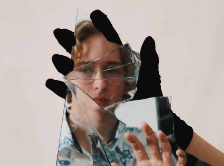 woman in black shirt covering face with hands