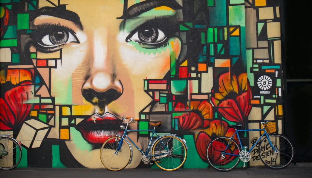 two blue cruiser bicycles on graffiti wall