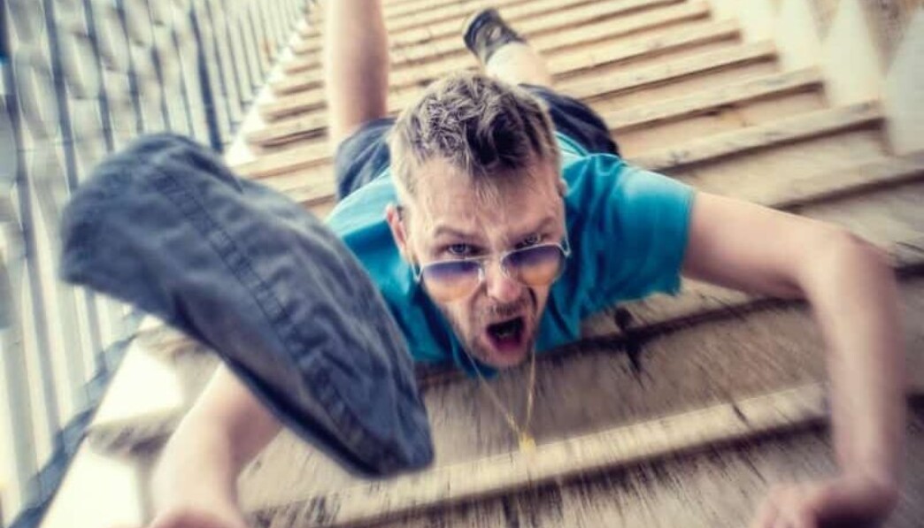 man in blue t-shirt and blue denim shorts sitting on concrete stairs during daytime