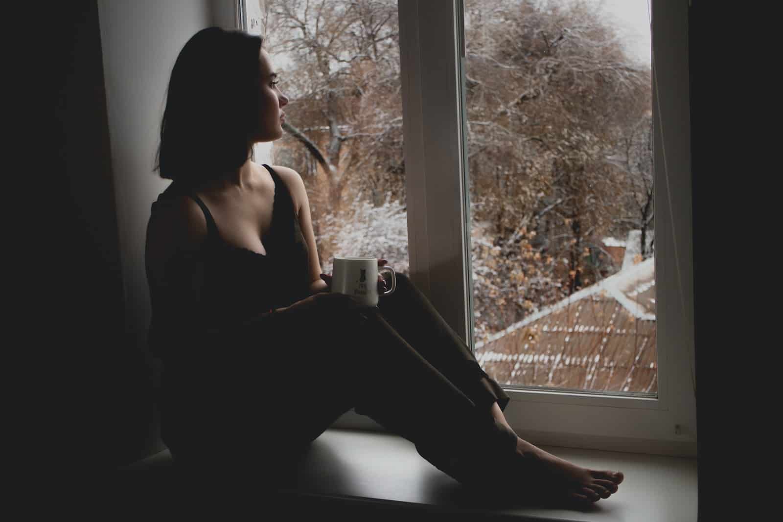 depressieve vrouw die voor het raam zit