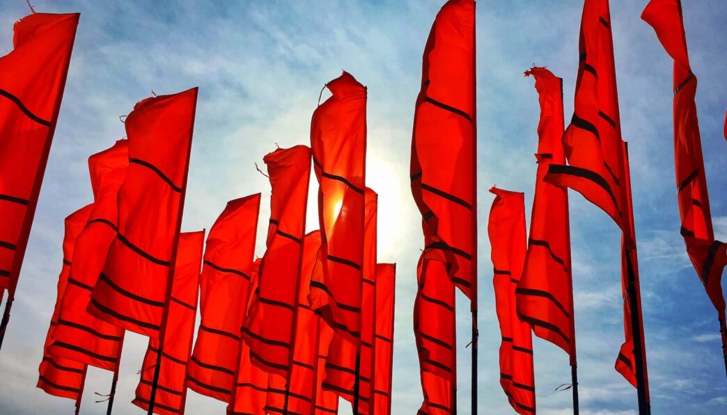 a bunch of red flags flying in the air