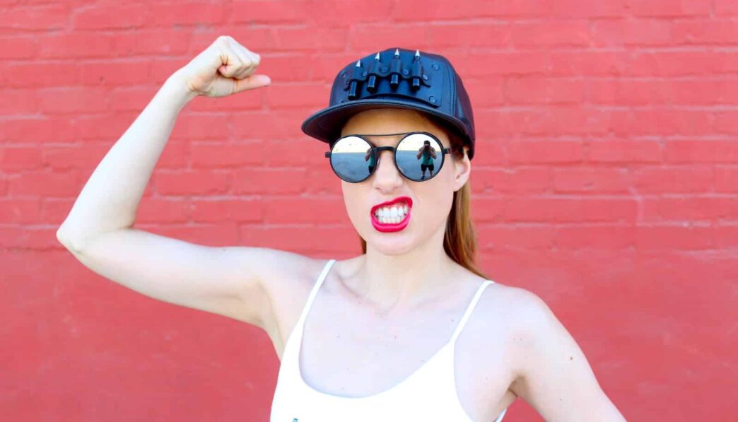 woman in white tank top wearing black sunglasses and blue and white fitted cap