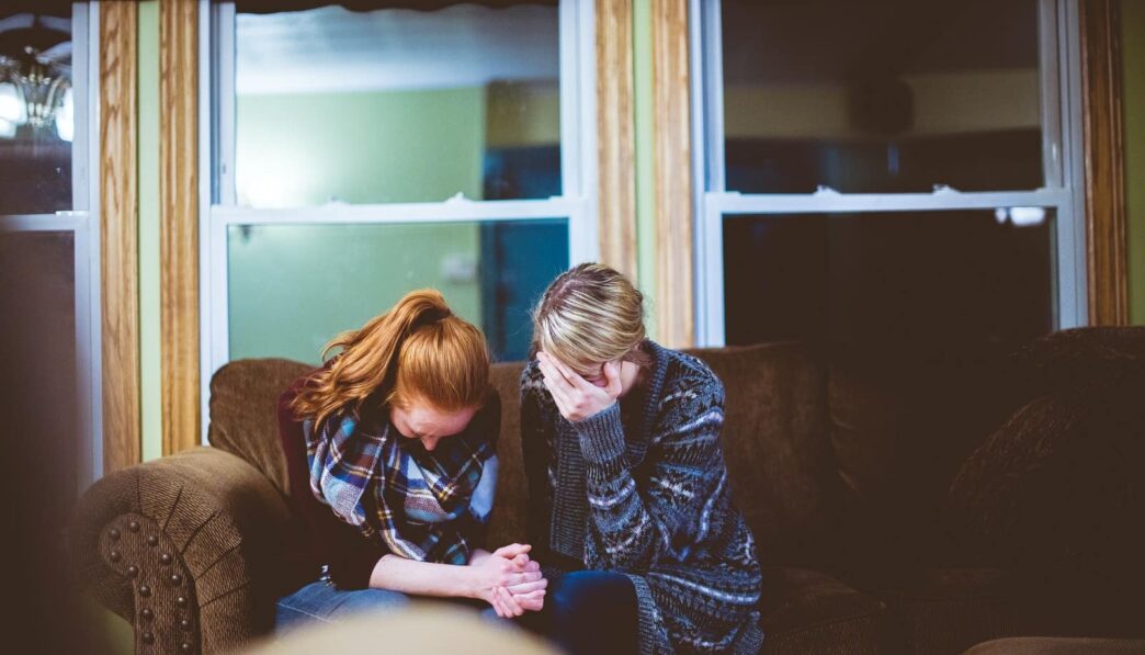 man and woman sitting on sofa in a room