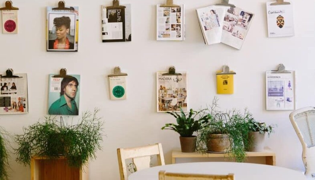 magazines hanged on wall near round beige wooden table