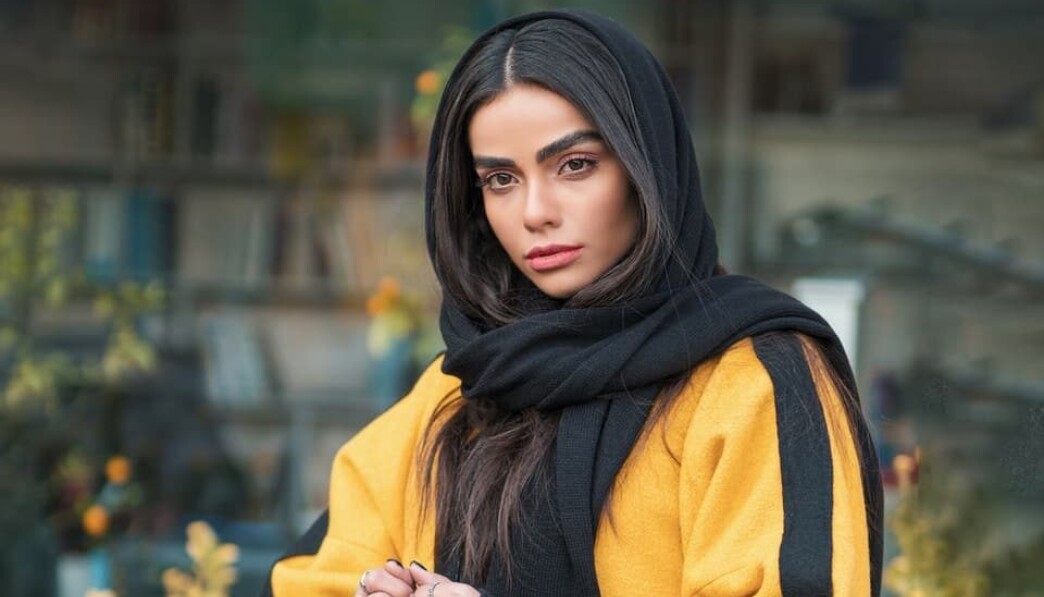 woman in yellow and black hijab and red leather sling bag