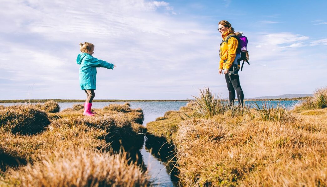 mother and daughter standing on cliffs