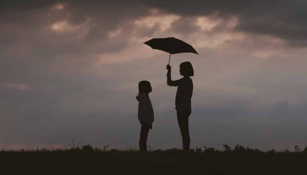 girl holding umbrella on grass field