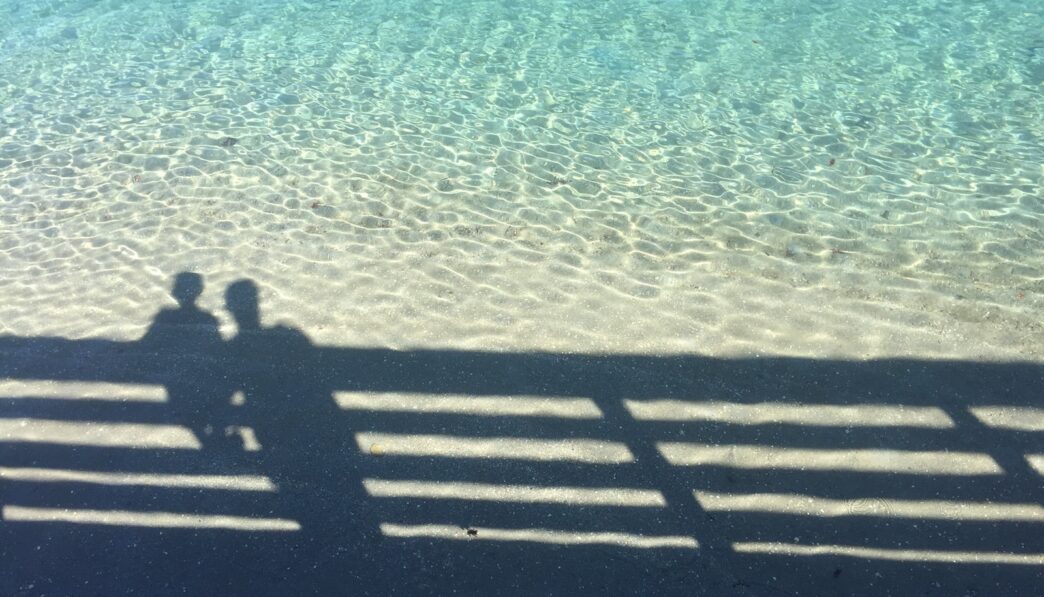 shadow of boy and man near fence