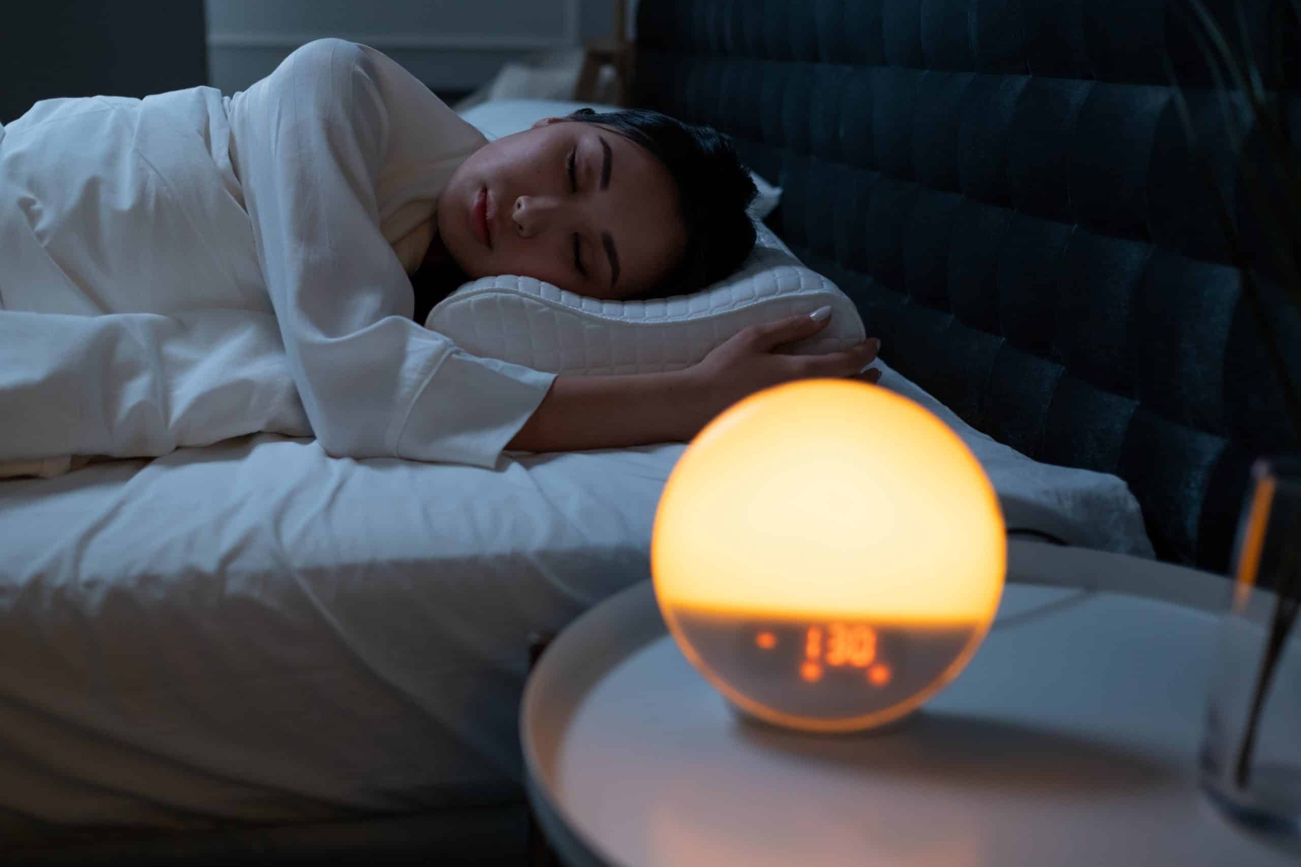 vrouw die slaapt naast een wake-up light
