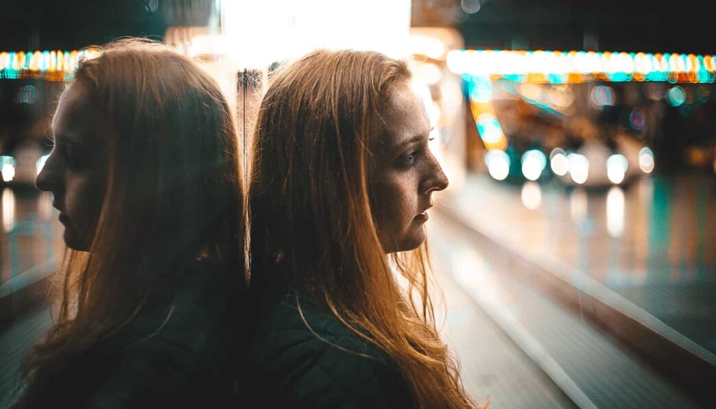 reflection of woman leaning against wall