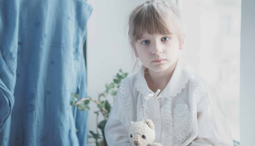 girl in white dress holding white bear plush toy