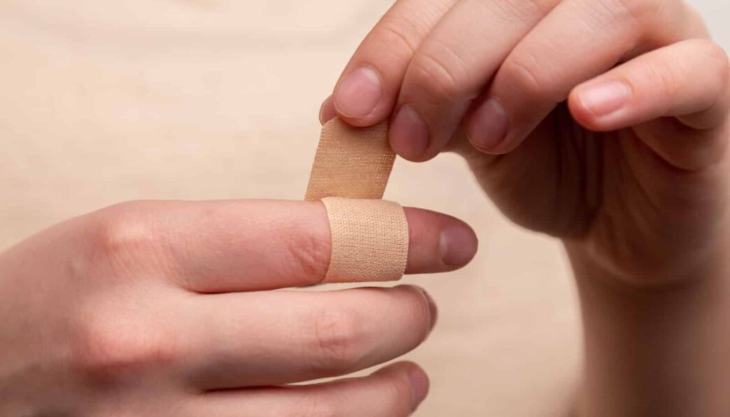 person with band aid on middle finger