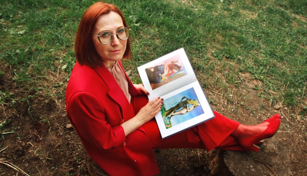 woman in red long sleeve shirt holding white picture frame