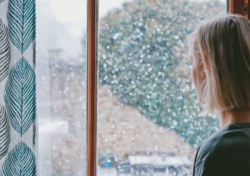 woman standing in front of clear glass window