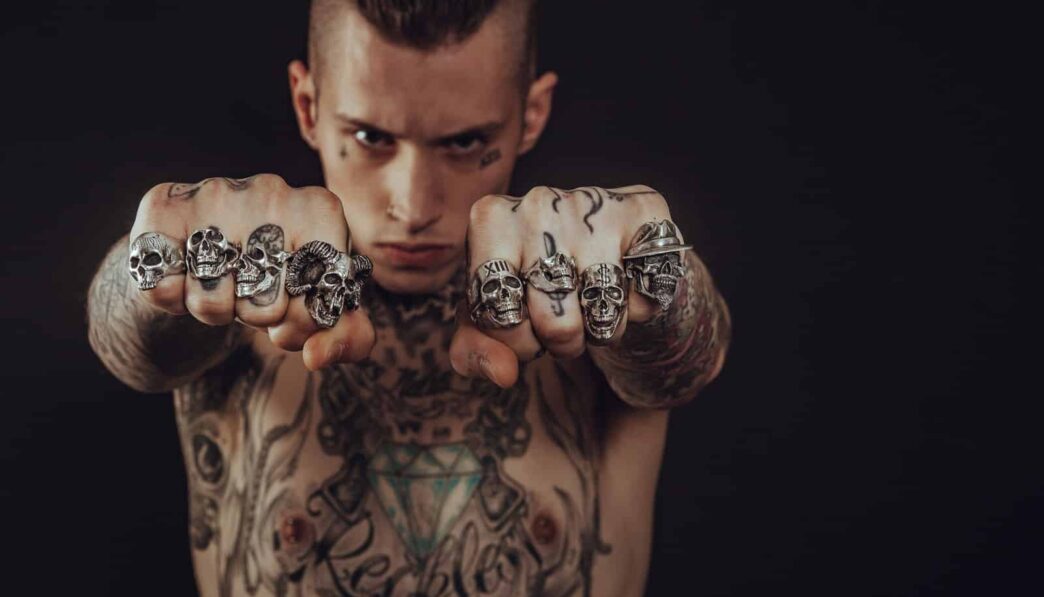 topless man showing his hands with nine silver-colored rings