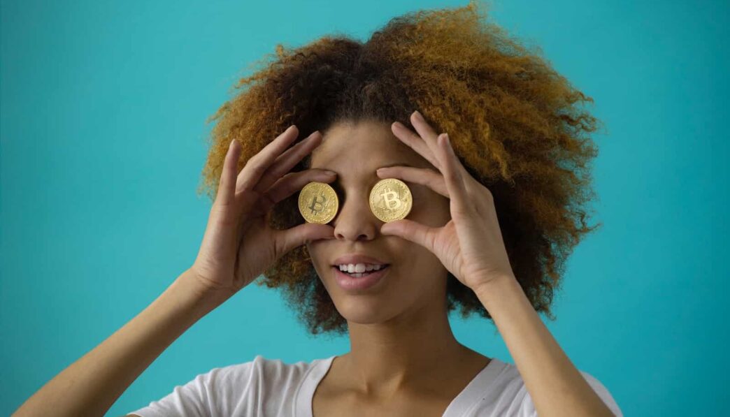 woman holding two round gold-colored coins