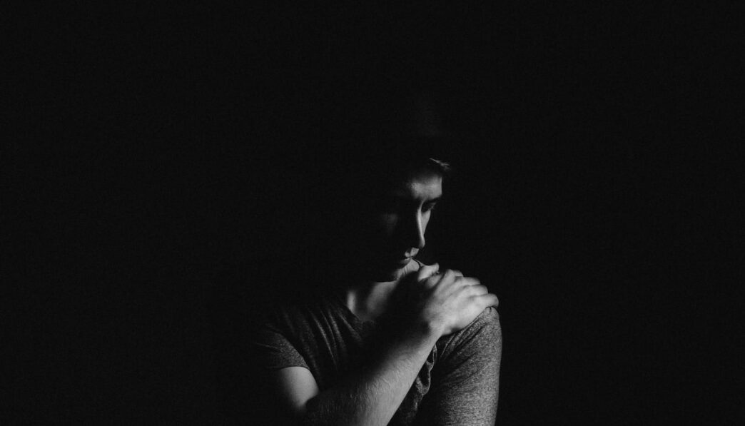 man holding his left shoulder