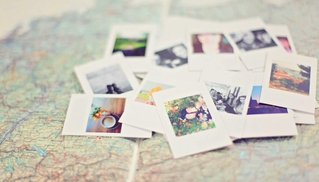 A collection of Polaroid memories spread across a map, symbolizing travel adventures.